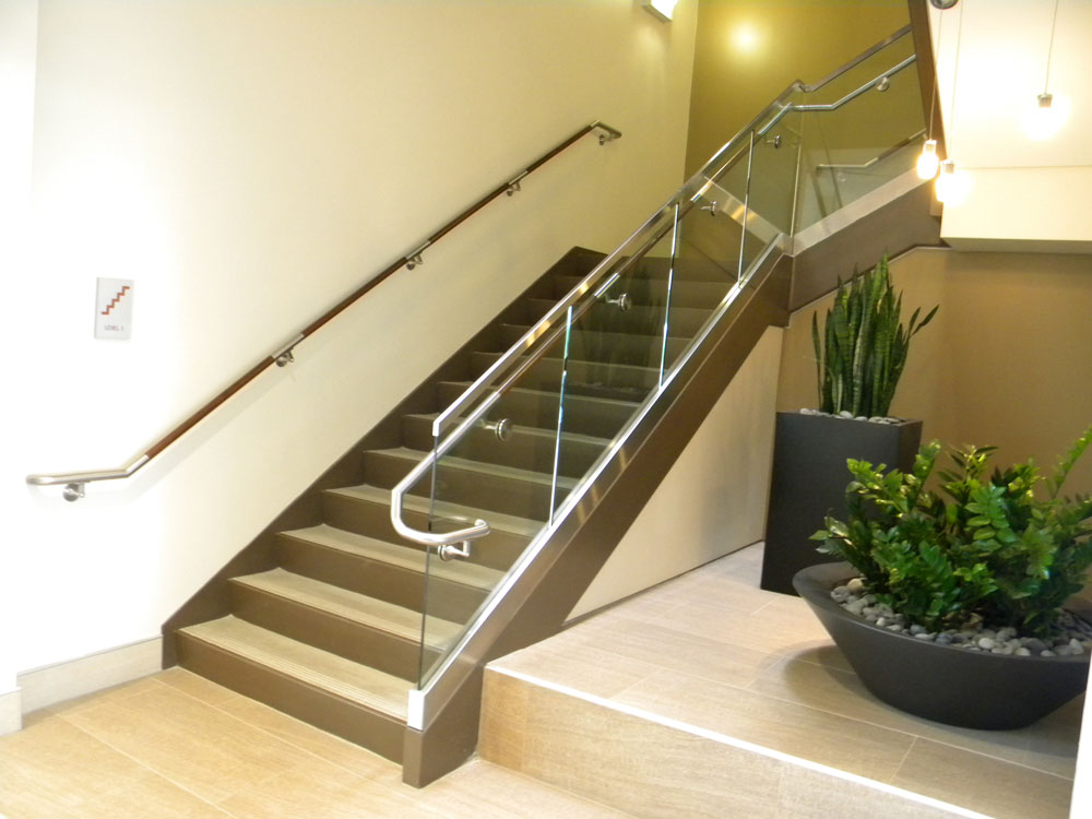 Rivulon - glass in shoe with stainless steel cladding. Stainless steel and wood handrail.