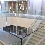 Scope: Stainless steel glass railings with painted steel base cladding.
